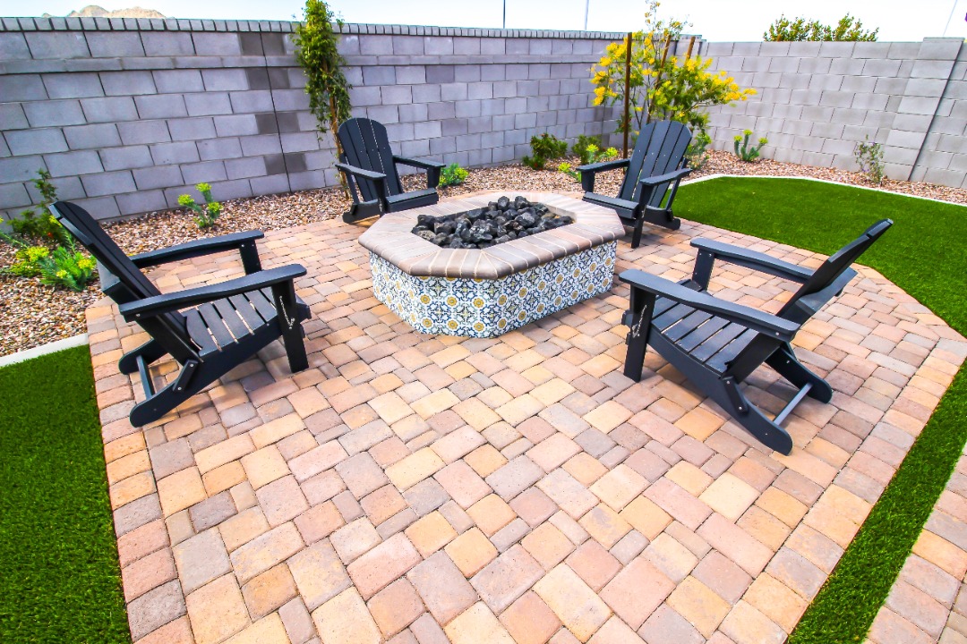 A gorgeous paver patio with a matching fire pit and furniture.
