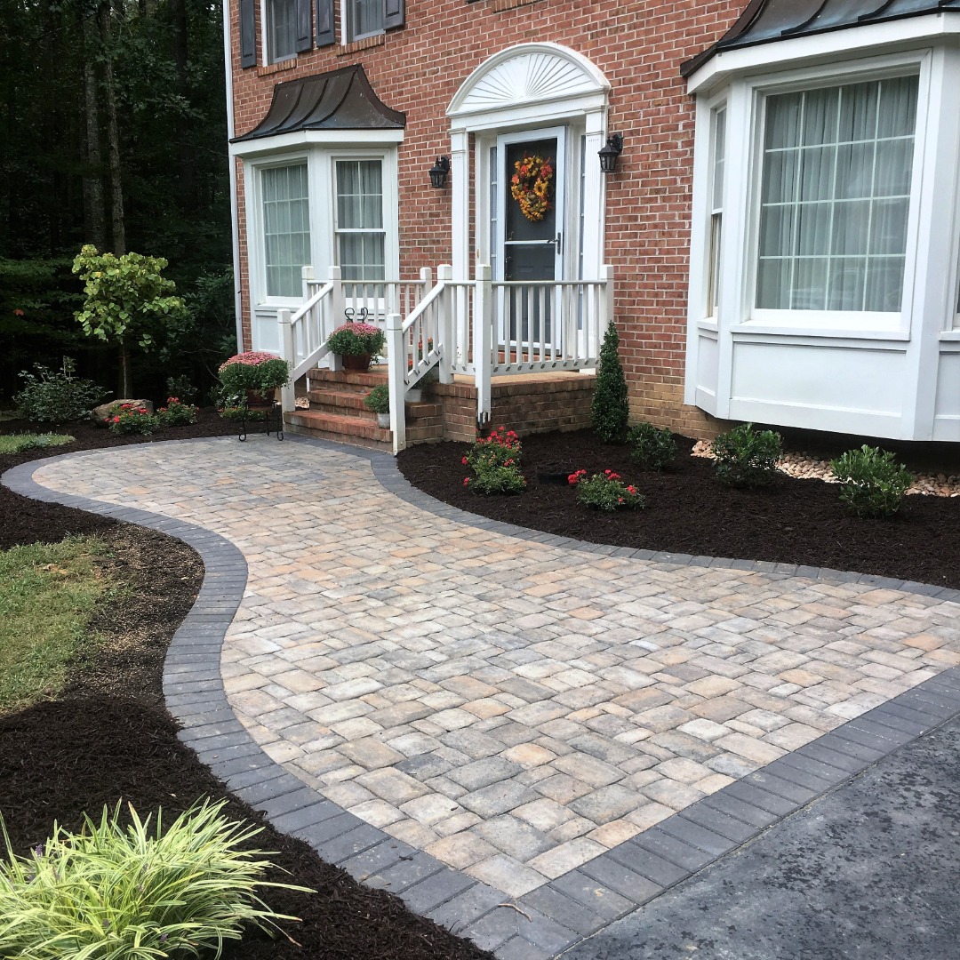 A gorgeous paver walkway that leads to the front door of a home.