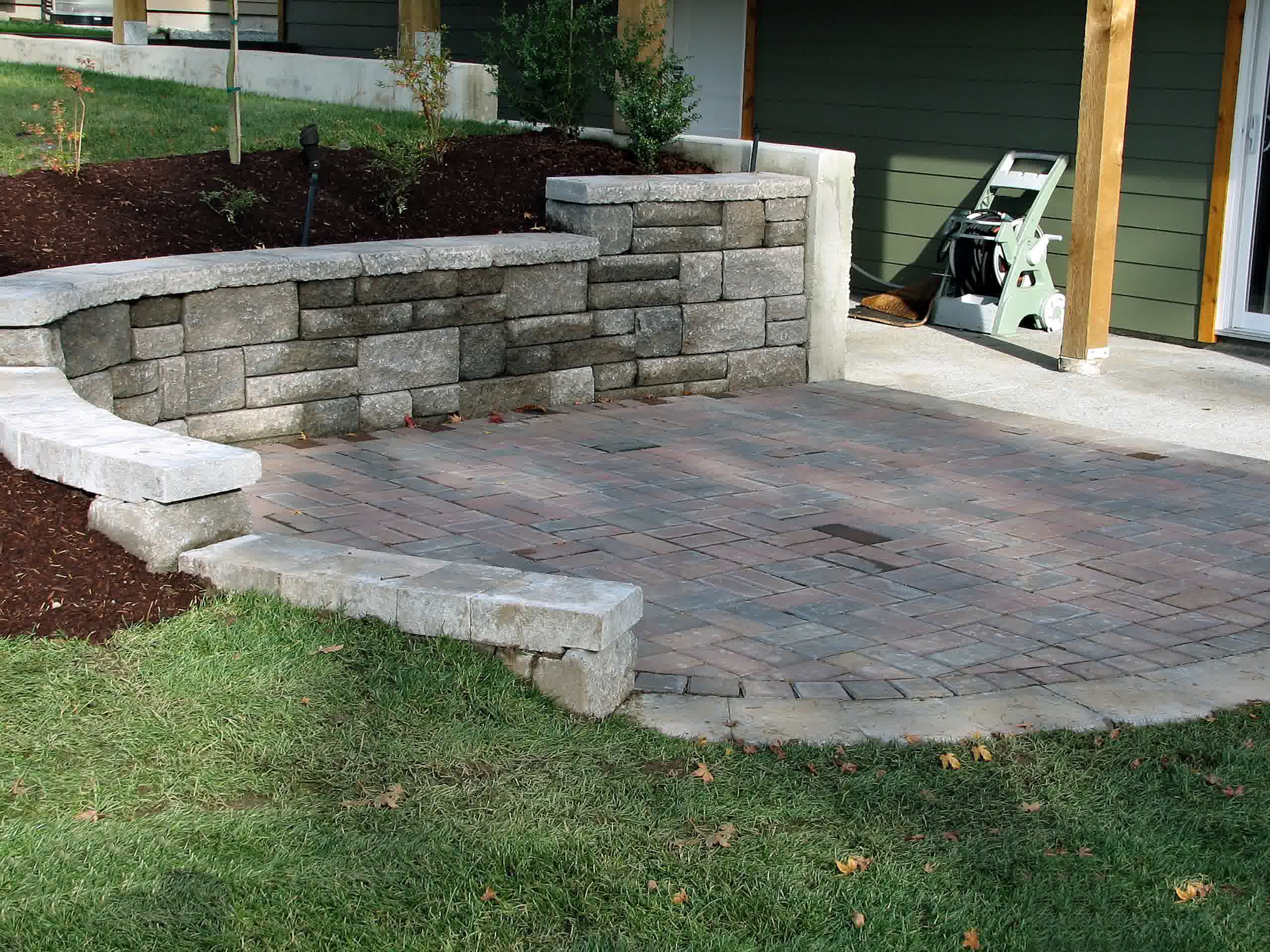A seamless retaining wall connected to a paver patio for the ultimate outdoor living area experience.